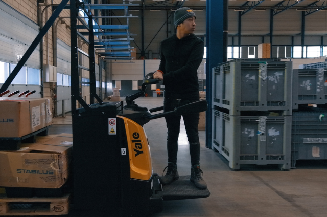 An operator using a pallet stacker