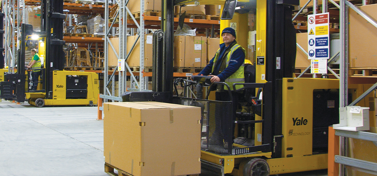 A warehouse worker operates a forklift