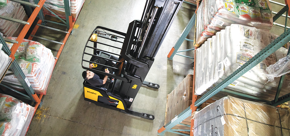 Reach truck operator looking up as he retrieves an
item from a high rack