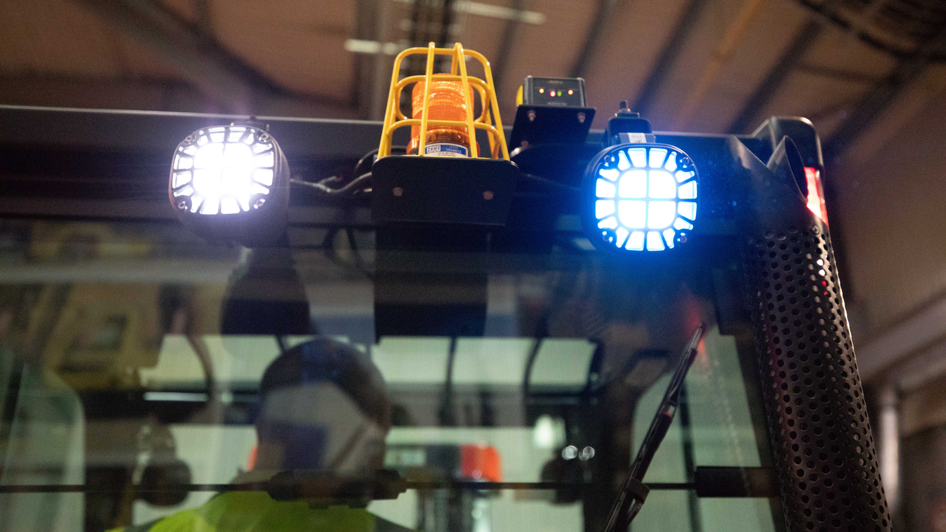 Close-up of activated forklift lights as an operator backs up 