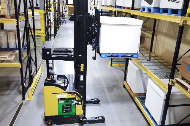 Robotic reach truck places a package onto a warehouse rack